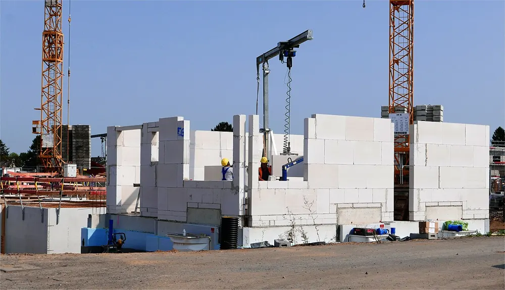 ساختمان مسکونی در حال ساخت با دیوارهای بلوکی و دو جرثقیل